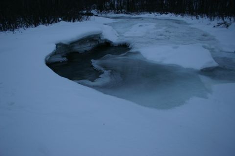 2003 Jeep TJ - A winter scene shows a river with ice forming along the edges and snow covering the banks.