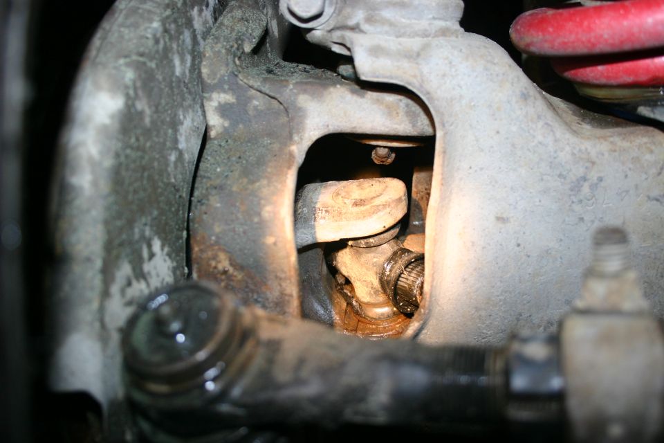 Close-up of front suspension components, including a U-joint and tie rod end