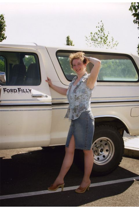 1976 Ford F-150 - A woman poses next to a white Ford Bronco, identified by the "Ford Filly" text on the door.