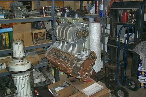 1978 Ford F-250 - A V8 engine with a prominent supercharger and dual carburetors sits in a cluttered garage or workshop.