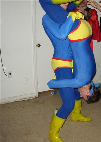 1991 Ford Bronco - Two individuals in blue and yellow superhero costumes are engaged in a playful pose, with one person carrying the other.