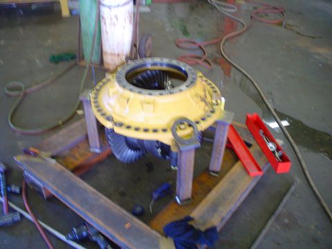 1966 International School Bus - A yellow differential assembly is shown on metal stands in a workshop setting.