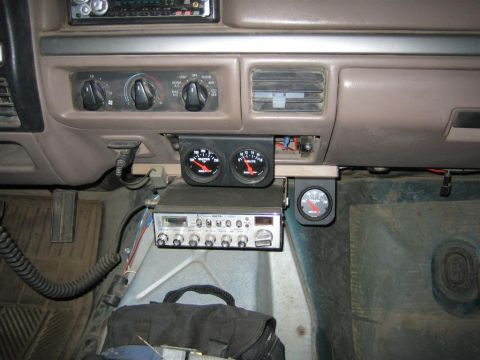 1994 Ford Bronco - Interior view of a vehicle's dashboard, showing aftermarket gauges and a CB radio installed.