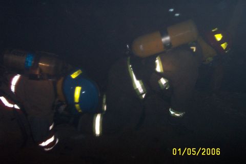 1998 Ford Crown Victoria - Two firefighters in protective gear are visible in a dark environment, with a date stamp of 01/05/2006.