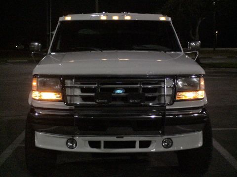1993 Ford C-350 (Centurion Conversions) - This 1993 Ford C-350 (Centurion Conversions) is captured from the front, its grille and illuminated headlights.