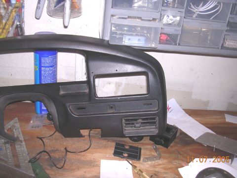 1994 Ford Bronco - A close-up view of a vehicle's dashboard switch panel, with various tools and a cleaning spray can on the workbench.