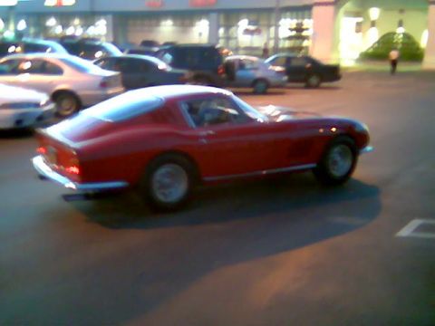 1986 Pontiac Fiero - A red coupe is parked in a lot with other vehicles visible in the background.