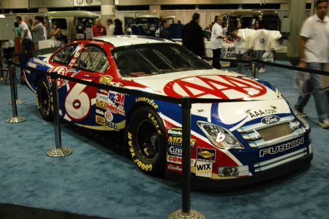 1991 Ford Taurus - A race car with prominent "AAA" and "Ford Fusion" branding is displayed indoors.