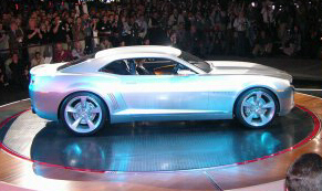 1968 Chevrolet Camaro - A silver concept car is presented on a rotating display platform in front of an audience.