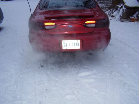 1997 Ford Taurus - Red 1997 Ford Taurus in snowy conditions, showing exhaust fumes.