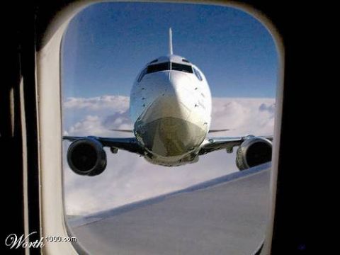 1972 Ford Ranchero - View from an airplane window shows the front of the aircraft against a blue sky with clouds.