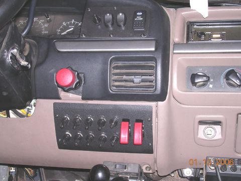 1994 Ford Bronco - Custom switch panel with numerous toggle switches and red rocker switches installed in a 1994 Ford Bronco interior.