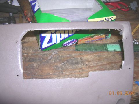 1994 Ford Bronco - A tan interior car panel with a large, irregular cutout is shown on a wooden surface, with a box of Ziploc bags and a ruler behind it.
