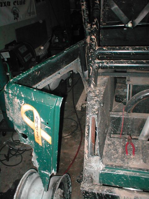 1983 Ford Bronco - A detached green vehicle fender with a yellow ribbon decal is shown in a workshop setting.