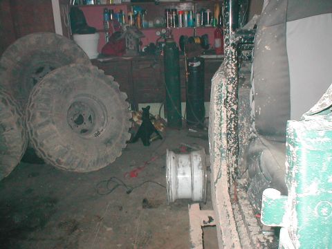1983 Ford Bronco - A vehicle interior is shown with several large tires and a spare rim in a garage setting.