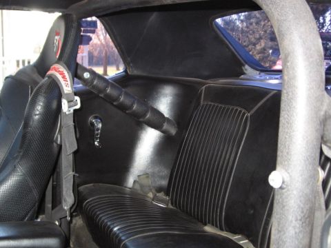 1983 Ford Bronco - The interior features racing seats, a roll cage, and a Simpson racing harness, suggesting a performance-oriented build.