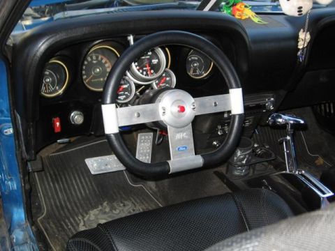 1983 Ford Bronco - Interior view of a car with custom steering wheel and gauges, a Ford logo.