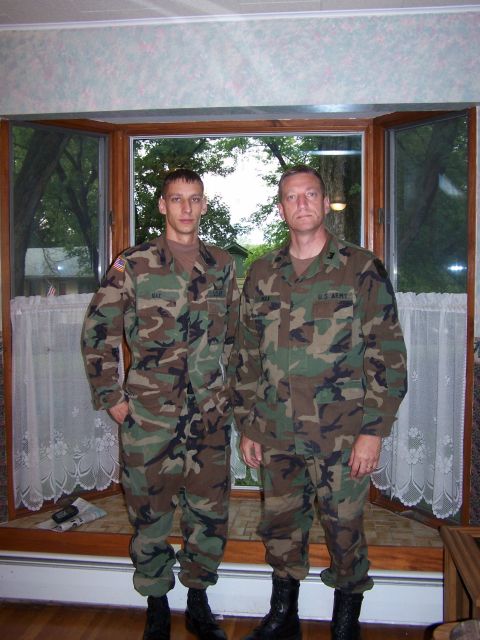 1983 Ford Bronco - Two soldiers in camouflage uniforms pose for a photo indoors, with a bay window behind them.