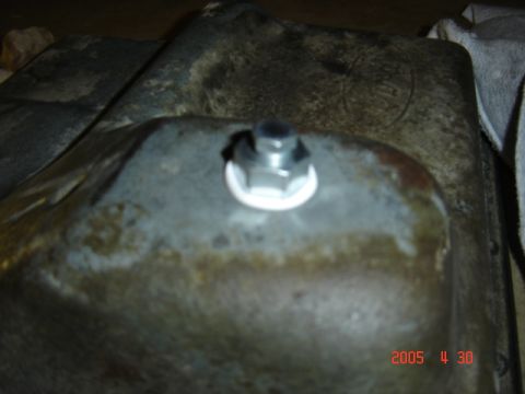 1990 Ford Bronco - Close-up of an oil pan drain plug, with a watermark indicating the source website.