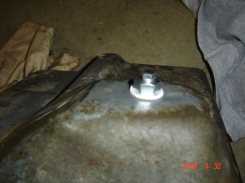 1990 Ford Bronco - A new drain plug is installed in a vehicle's oil pan, likely during maintenance.