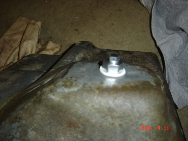 close-up of a new drain plug installed in an oil pan