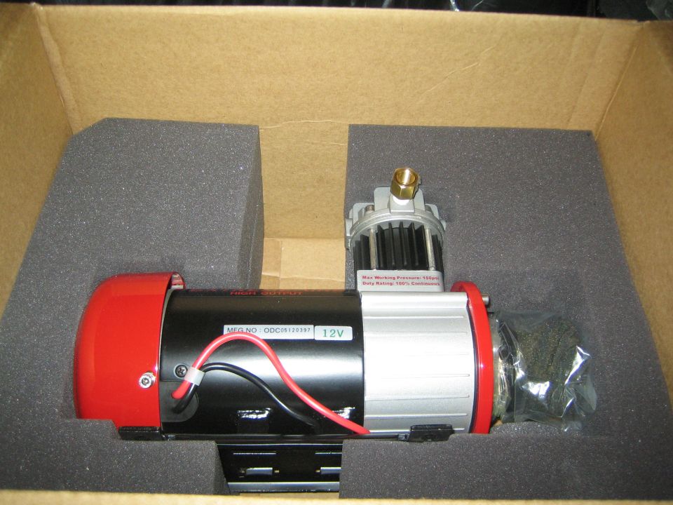 12V winch motor with red housing packed in foam inside a cardboard box