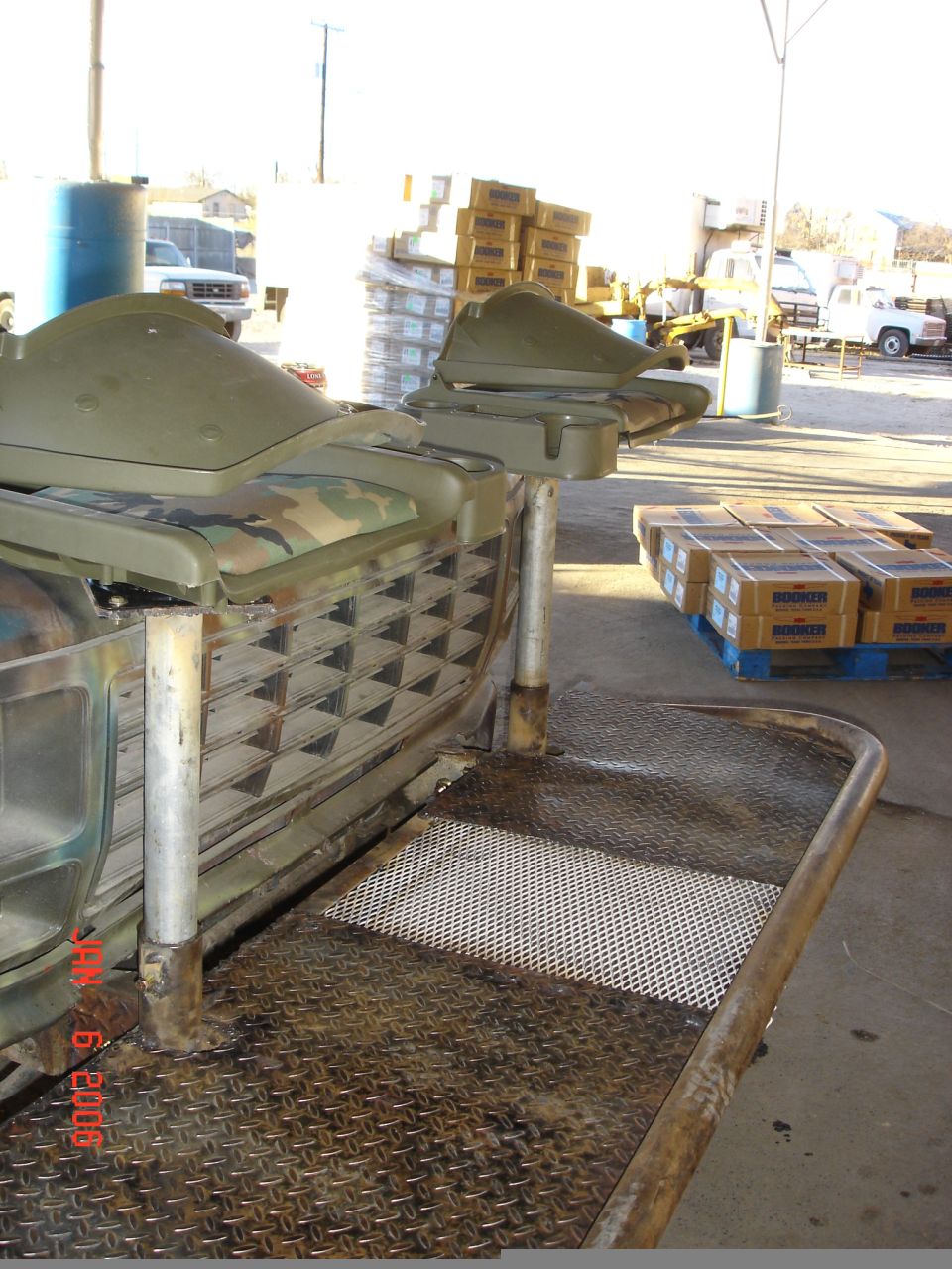Close-up of a modified vehicle part with camouflage seat and diamond plate platform