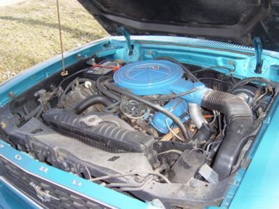 1978 Ford Mustang II - The engine compartment of a teal-colored vehicle is shown with the hood raised.