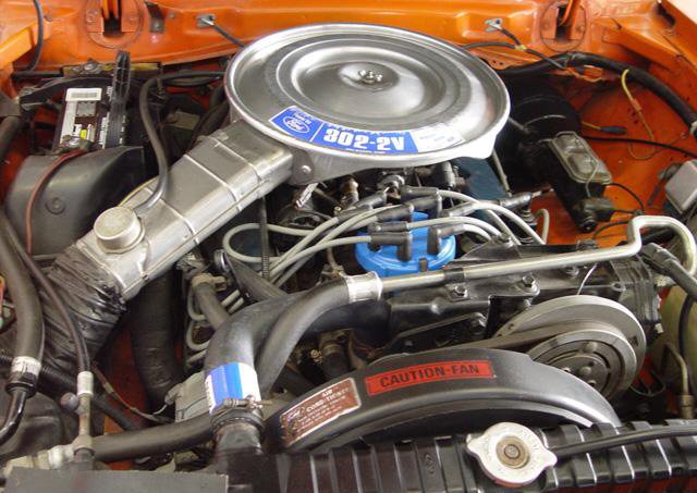 Orange engine bay with Ford 302-2V air cleaner, visible hoses, and fan shroud