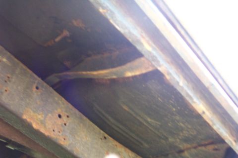 1975 Ford F-150 - The undercarriage of the truck shows significant rust and wear on the frame and suspension parts.