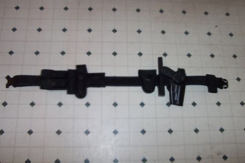 1998 Ford Crown Victoria - A black duty belt with various pouches and a handgun is laid out on a tiled surface.