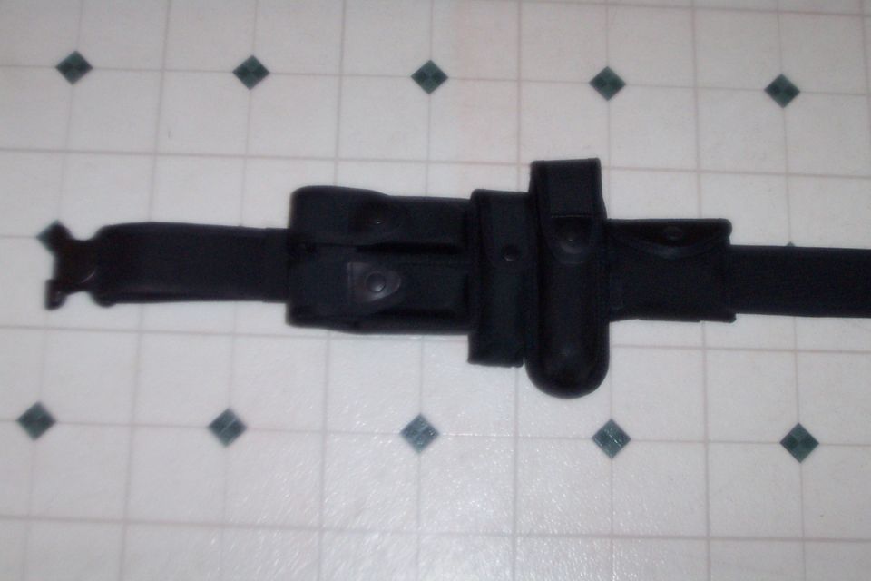 Black duty belt with multiple pouches for flashlight, handcuffs, and other equipment