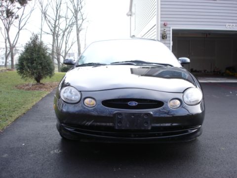 1998 Ford Taurus - Front view of a black Ford Taurus parked in front of a garage.