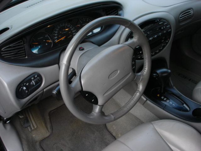 Gray interior of a 1998 Ford Taurus showing dashboard, steering wheel, and center console