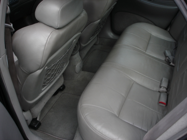 back seat of a car with gray leather seats and seatbelts