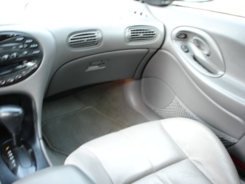 1998 Ford Taurus - The interior of a 1998 Ford Taurus features a gray dashboard with air vents and a center console with an automatic shifter.