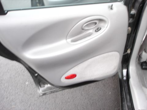 1998 Ford Taurus - Close-up of a car's interior door panel, showing the handle and speaker grille.