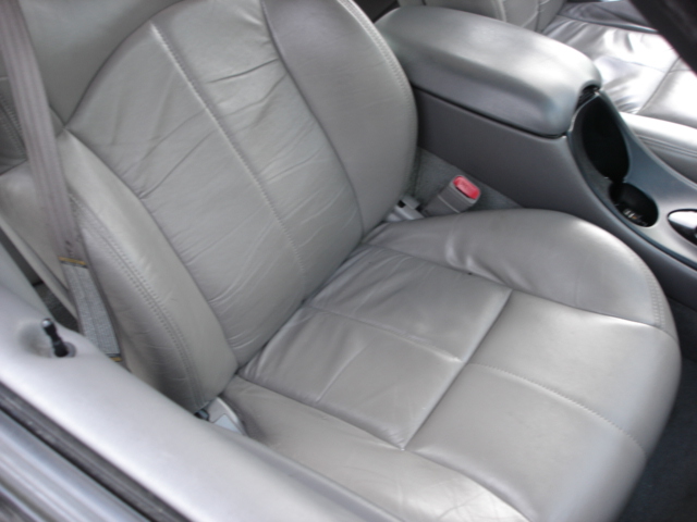 Gray leather car interior showing front passenger seat and center console with cup holders