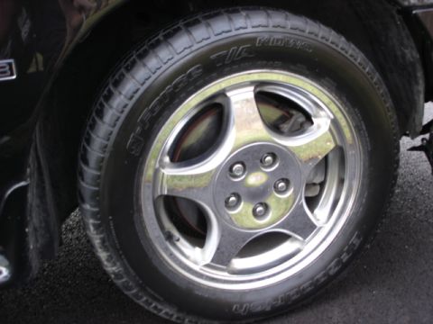 1998 Ford Taurus - Close-up of a car's wheel and tire, showing chrome spokes and tire tread.