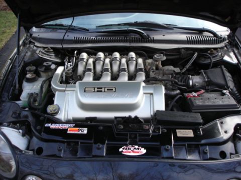 1998 Ford Taurus - The engine bay of a 1997 Ford Taurus SHO is visible, the V8 engine and various components.