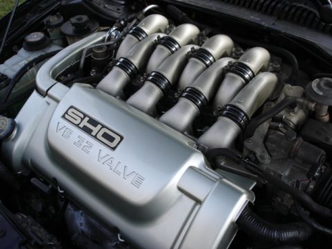 1998 Ford Taurus - Ford Taurus SHO V8 32-valve engine showing polished silver intake runners and SHO valve cover badge under hood.