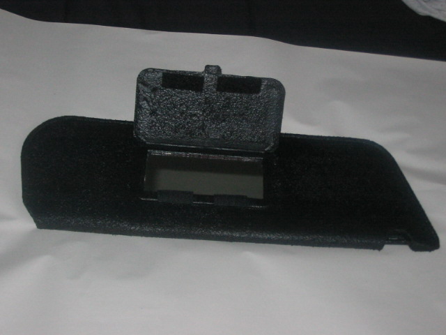 Black dashboard part with flip-up cover and mirrored compartment