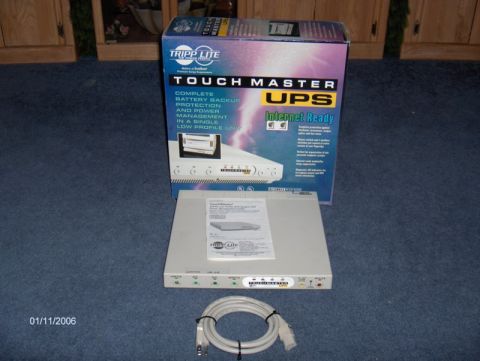 1994 Mazda MX-6 - A Tripp Lite Touch Master UPS unit and its packaging are displayed on a carpeted floor.
