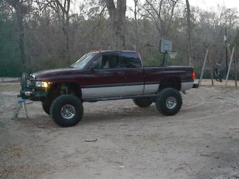 2001 Dodge 1500 - Lifted 2001 Dodge 1500 pickup truck with custom front bumper and large tires.