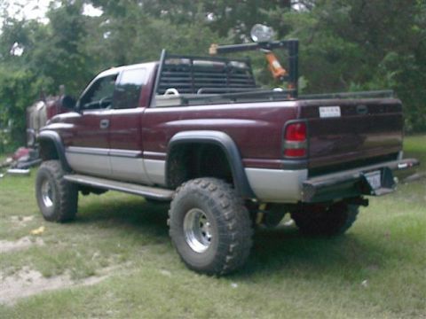 2001 Dodge 1500 - This lifted 2001 Dodge 1500 pickup truck features a two-tone paint scheme and a utility rack in the bed.