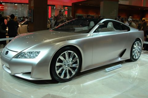 1991 Ford Taurus - A futuristic silver concept car is showcased indoors with a 'Please Stay Off The Display' sign visible.