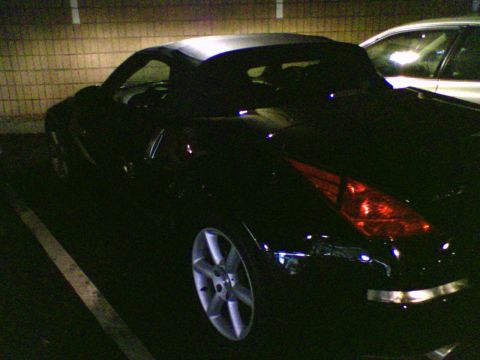 2004 Nissan 350Z - Rear 3/4 view of a black 2004 Nissan 350Z convertible parked at night.