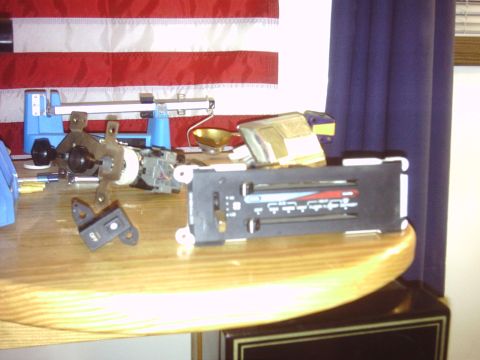 1996 Ford Bronco - Various automotive parts, including a radio and a switch, are laid out on a wooden surface.