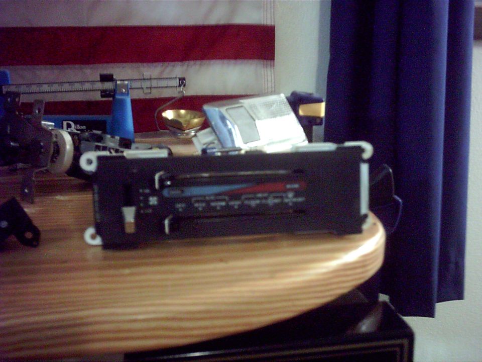 Car radio control panel with sliders and buttons on a wooden table