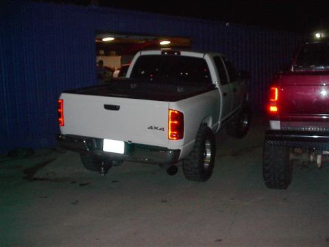 2001 Dodge 1500 - A white Dodge Ram pickup truck is parked next to a red pickup truck.